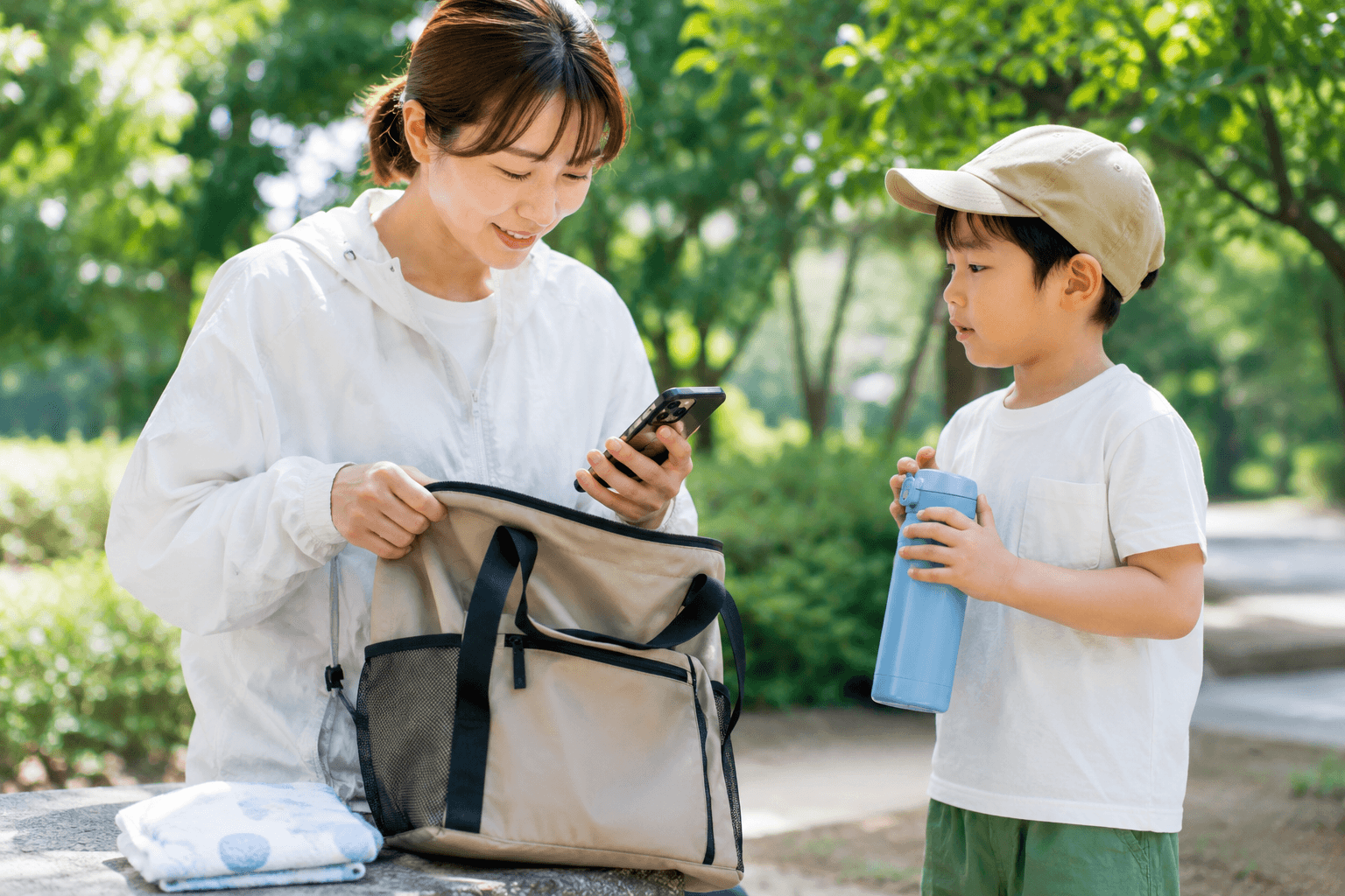夏の屋外で持ち物をチェックする家族