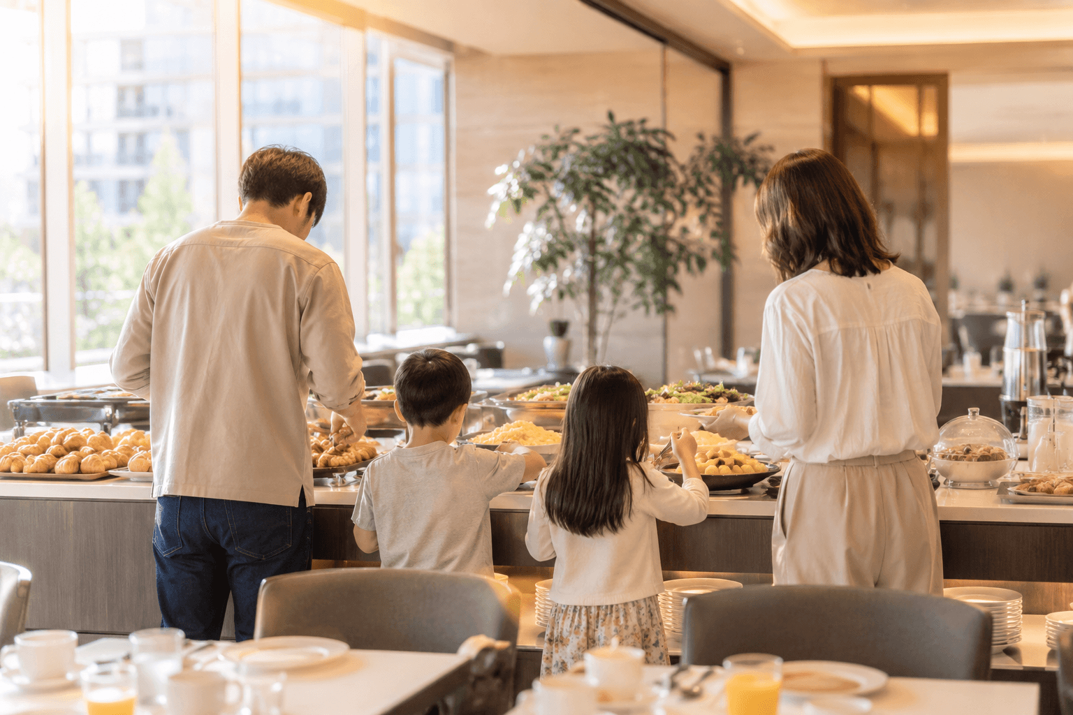 ホテル朝食ビュッフェを楽しむ子連れファミリーの後ろ姿イメージ