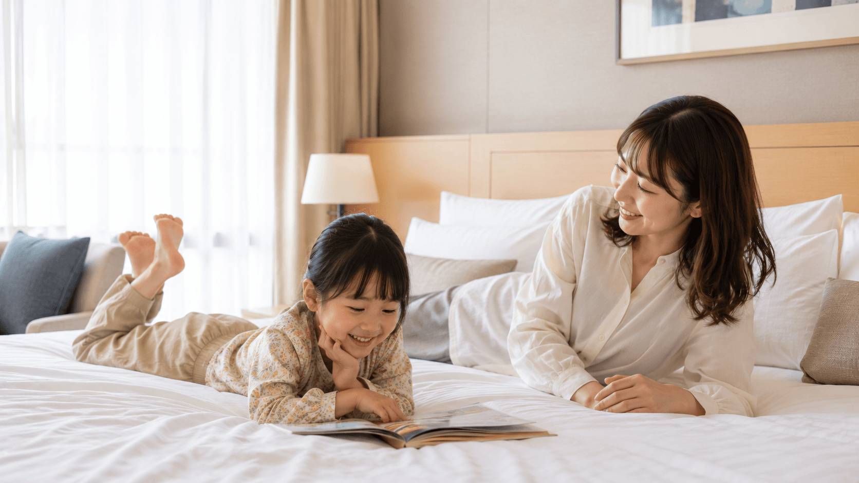 ホテルのベッドでくつろぐ子どもと見守る親のイメージ