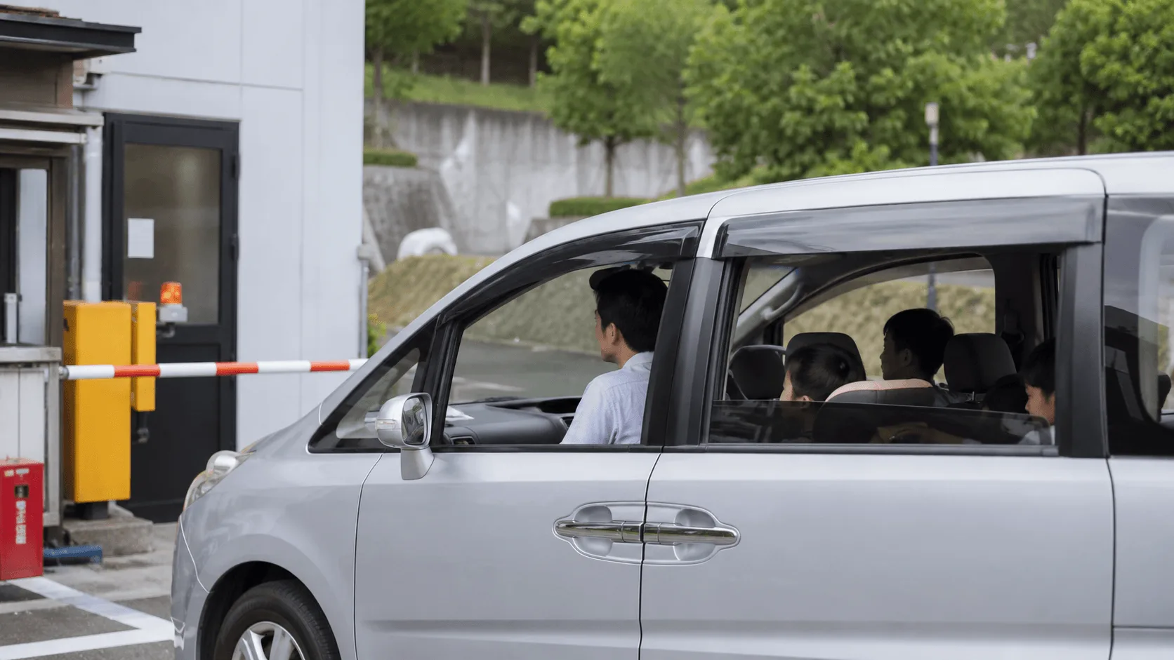駐車場の入口ゲートで順番を待つ家族の車
