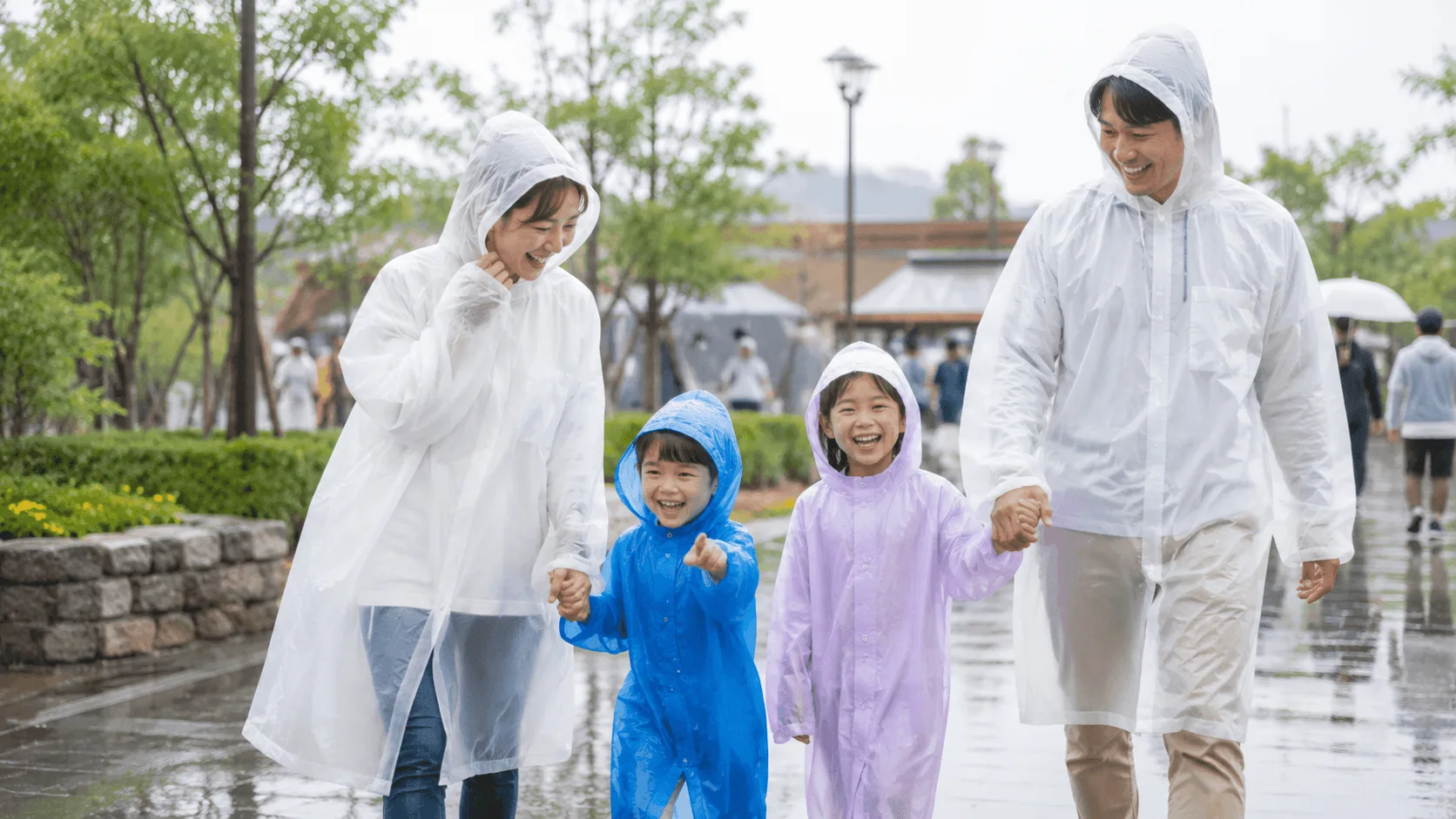 雨の日にテーマパークを楽しむ家族やカップルのイメージ