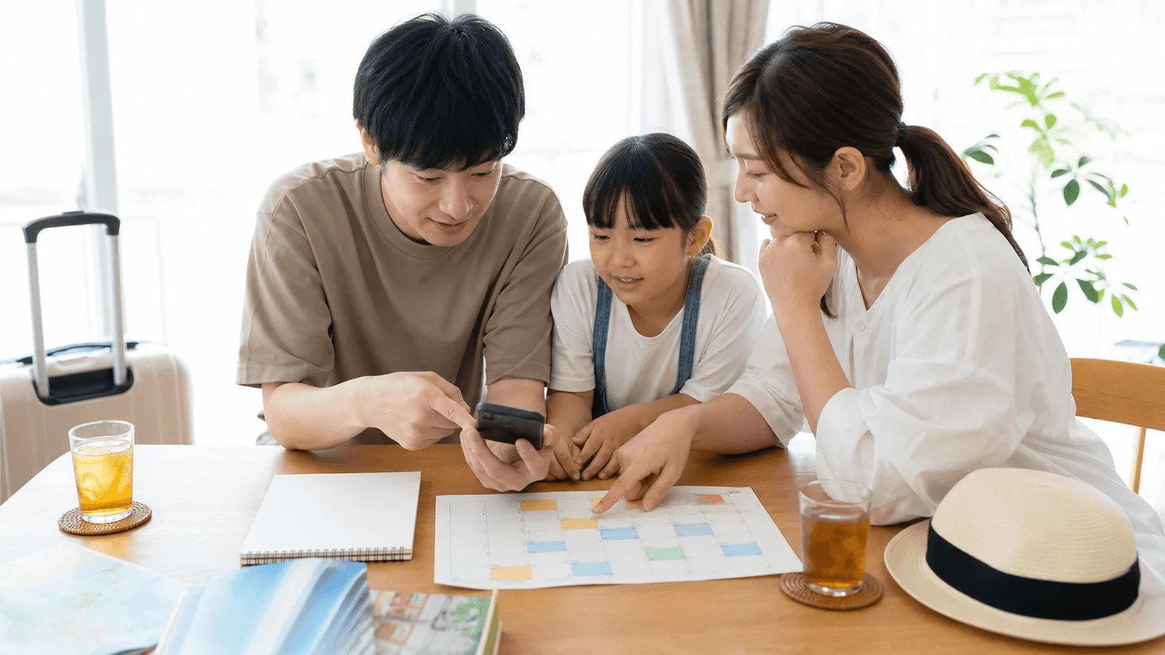 夏休みのテーマパーク旅行を家族で計画するイメージ