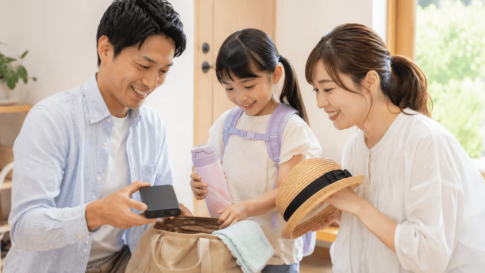 テーマパークへ出かける家族が持ち物を準備しているイメージ