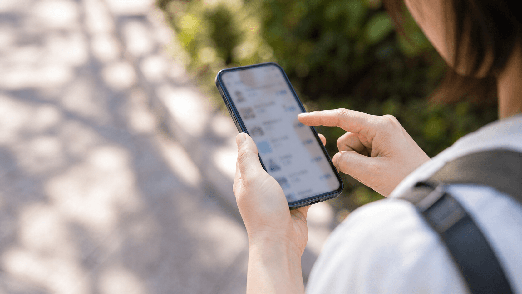 テーマパークの混雑と待ち時間をスマホでチェックする手元