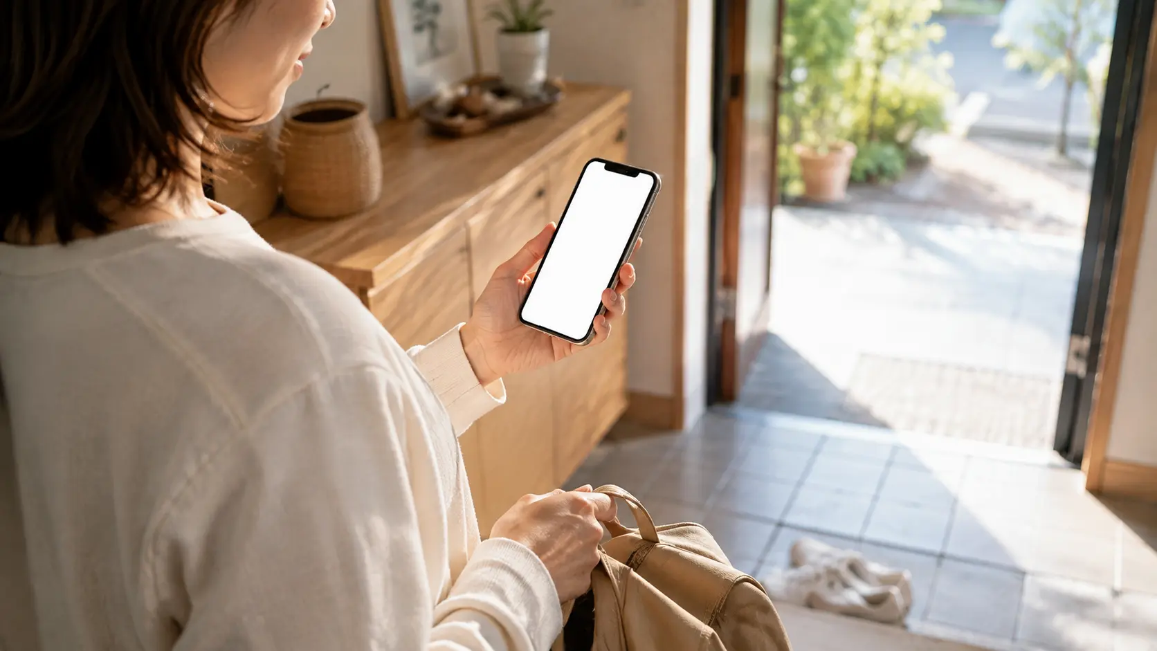 出かける前にスマートフォンで当日の運営状況を確認しているところ