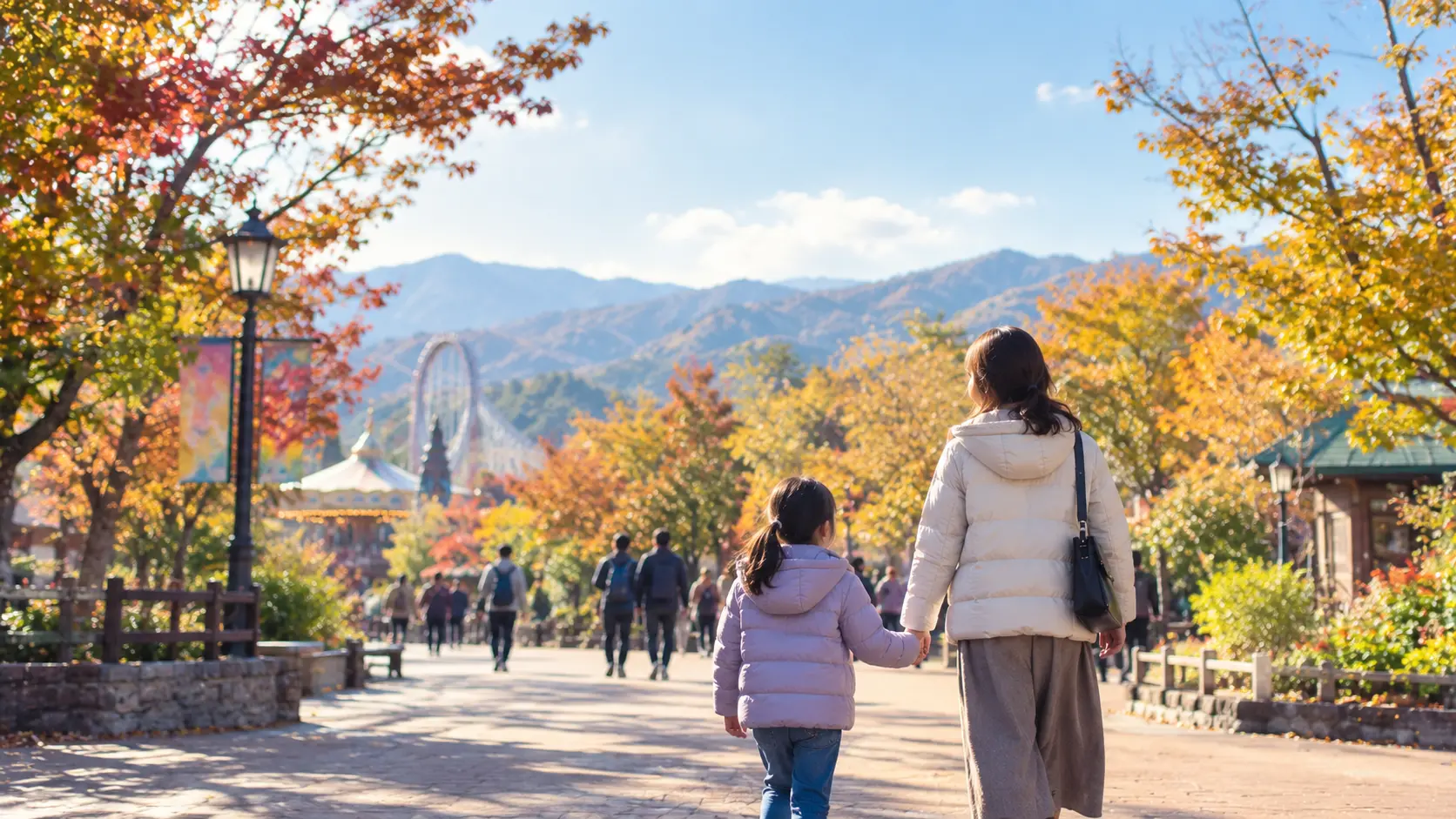 色づき始めた木々の通路を上着を羽織って歩く母親と子どもの後ろ姿